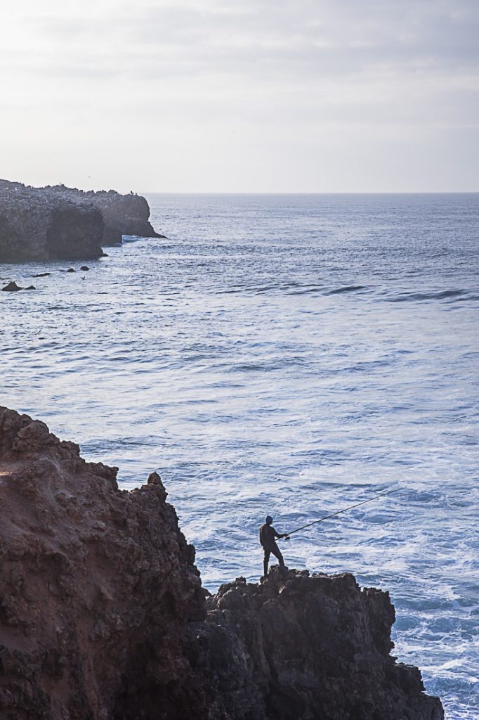 Le pêcheur de Carrapateira à flanc de falaise et proche des vagues