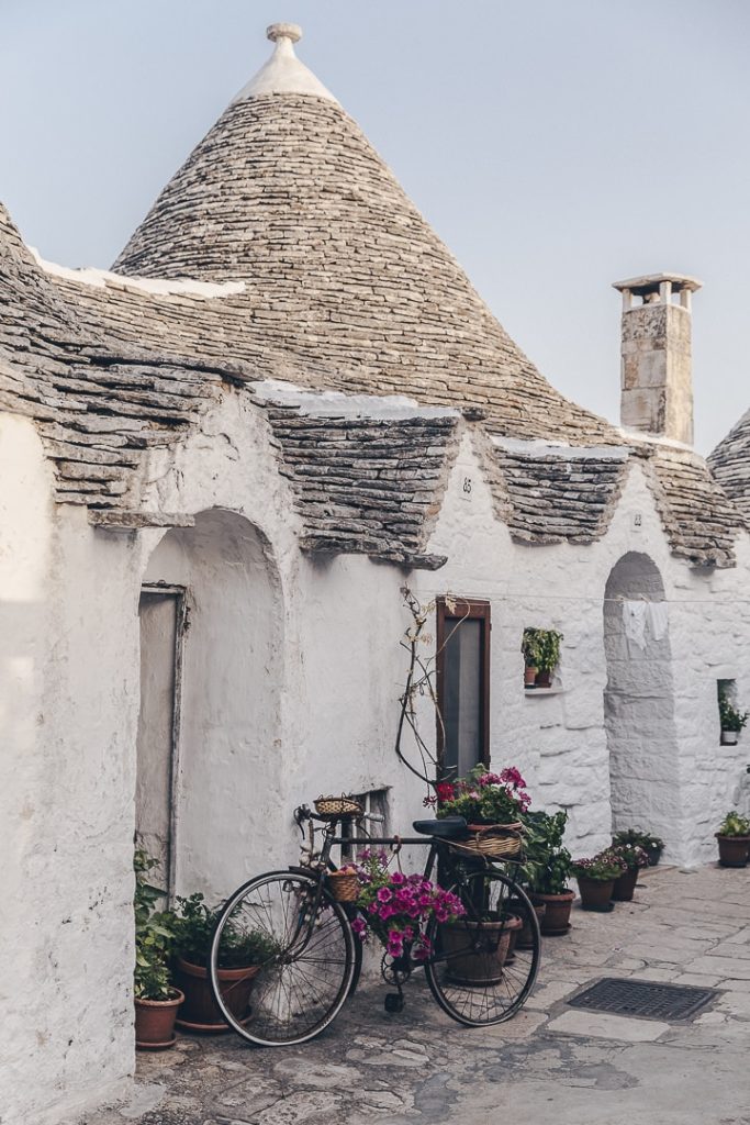 Bicyclette décorée de fleurs dans une ruelle pittoresque d'Alberobello
