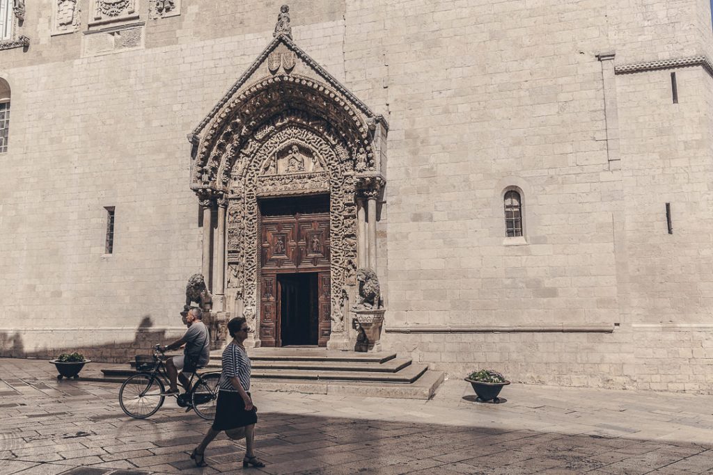 Porte de la cathédrale d'Altamura et des personnes se promenant dans la rue