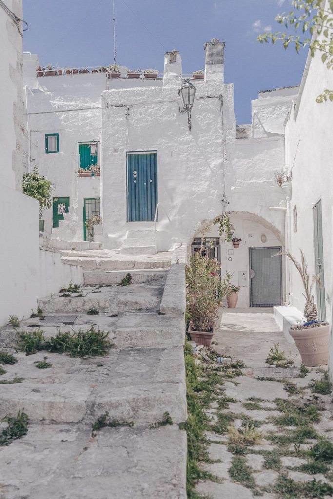 Maisons blanches et portes bleues dans les ruelles traditionnelles d'Ostuni