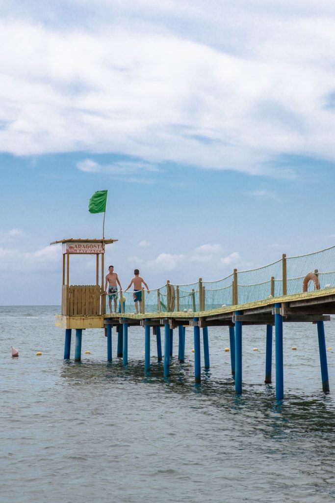 Jeunes garons plongeant dans la mer depuis un ponton sur la riviera albanaise