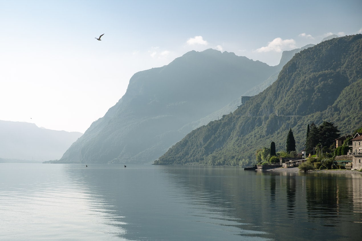 vue brumeuse sur le lac de côme avec les collines se reflétant dans l'eau