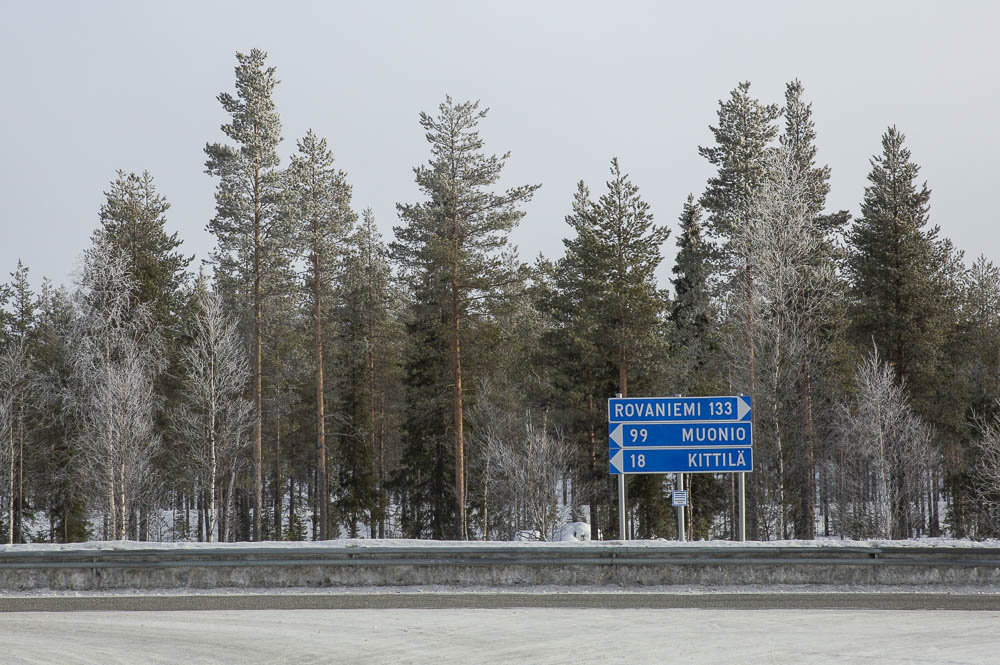 panneaux de signalisation bleus avec des sapins enneigés en arrière plan en Laponie