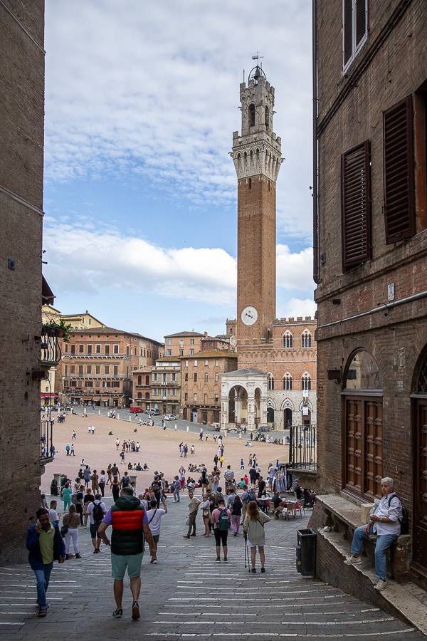 Vue de la Torre del Mangia à Sienne, s’élevant au-dessus de la Piazza del Campo avec son architecture gothique en briques rouges